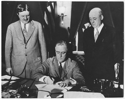 President Franklin D. Roosevelt signs a bill.