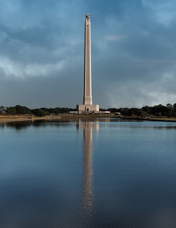 Tall tower with star on top in front of a reflection pool