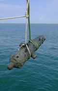Roped cannon hanging mid-air over the ocean