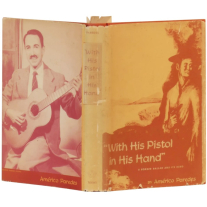 Photograph of a vintage hardcover book titled "With His Pistol In His Hand" by Americo Paredes. Cover artwork shows an illustration of a Texas Mexican cowboy resting against a tree while holding a pistol. Back cover artwork depicts a photograph of author Americo Paredes strumming an acoustic guitar and smiling. 