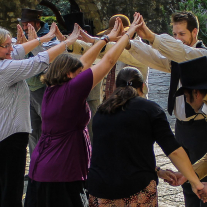 Contra dancing. Four couples make a bridge with their hands while the head couple walks under.