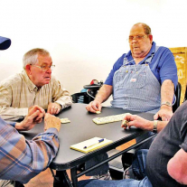 Men playing parlor games around a table. 