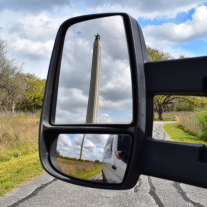 Reflection of San Jacinto Monument in side view mirror of a van