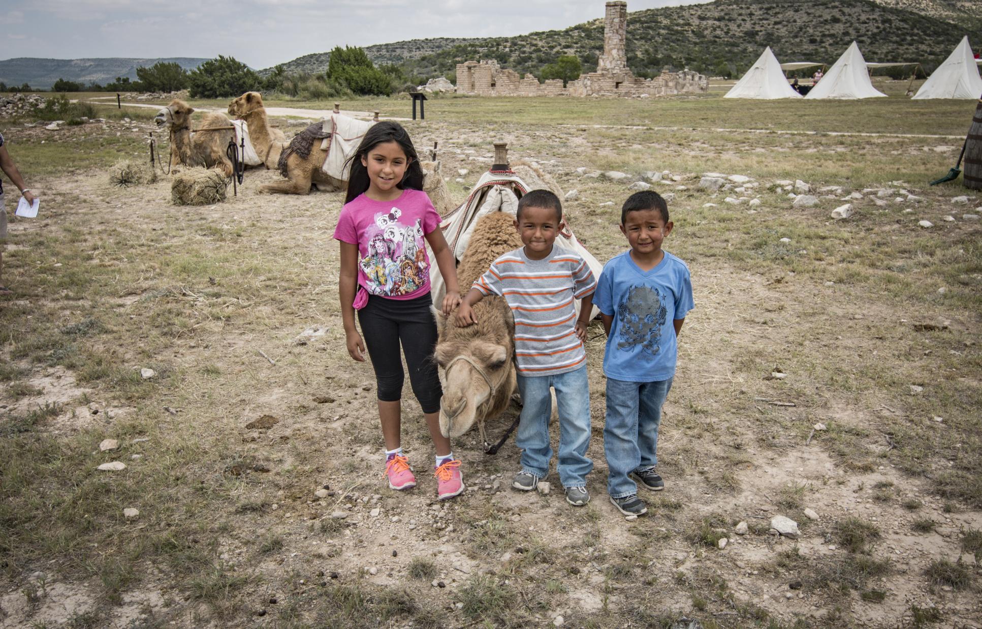 Children with a camel laying down